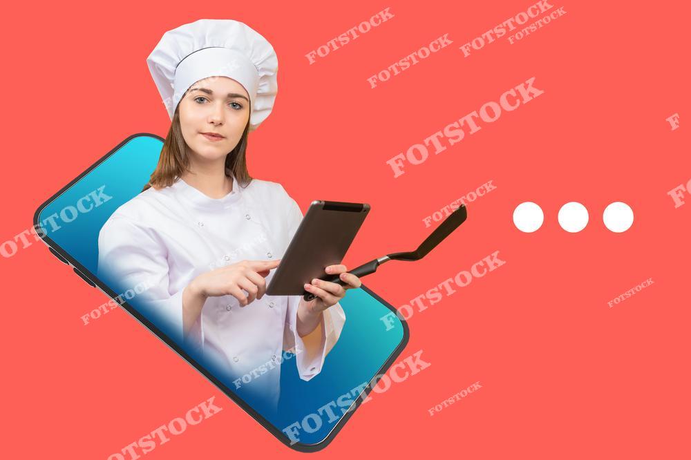 Фото демонстрирует концепцию кулинарных и cooking-приложений. Фотография показывает женщину-повара на экране смартфона на красном фоне, держащую электронный планшет и кухонную лопатку. Фотоснимок подчёркивает использование мобильных приложений для шеф-поваров, цифровые рецепты и современные инструменты для работы на профессиональной кухне.